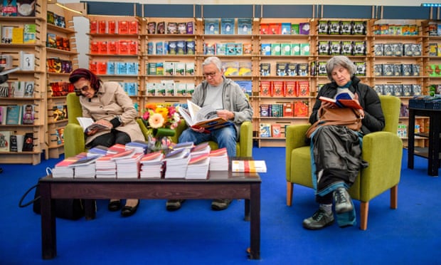 Посетители фестиваля читают в книжном магазине на литературном фестивале в Челтнеме, входящем в
