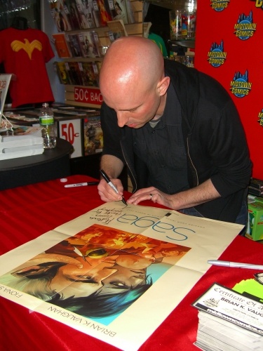 Брайан К. Вон на выставке New York Comic Con в 2014 году подписывает плакат для фаната.