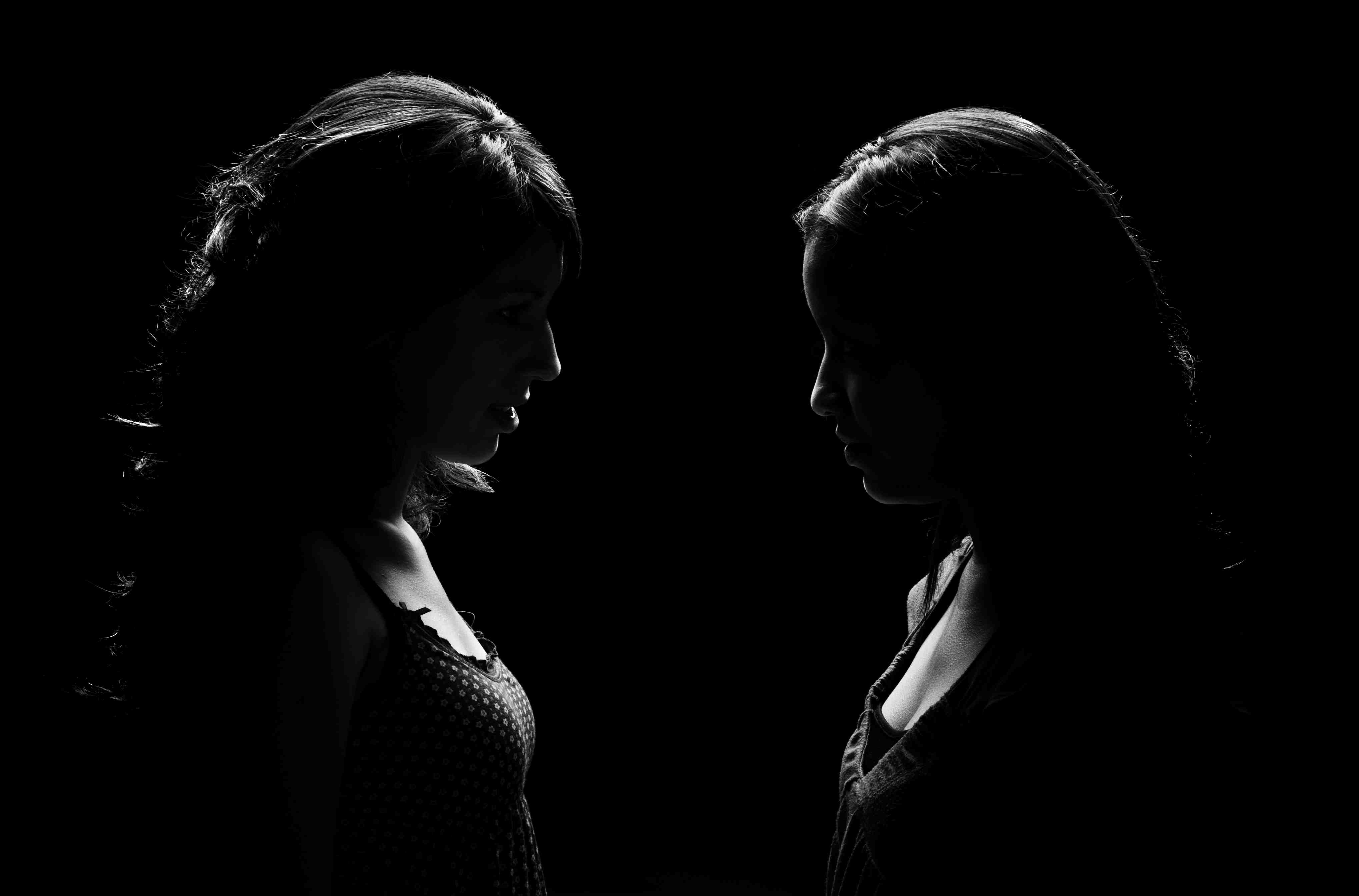 Идти друг напротив друга. Два силуэта в темноте. Мужчина с девушкой в темноте. Ссора на черном фоне. Стоят друг напротив друга.