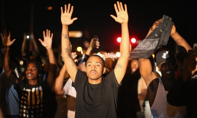 Демонстранты на протесте против убийства подростка Майкла Брауна (городок Фергусон, штат Миссури, август 2014).   Фотограф: Скотт Олсон (Scott Olson/Getty Images)